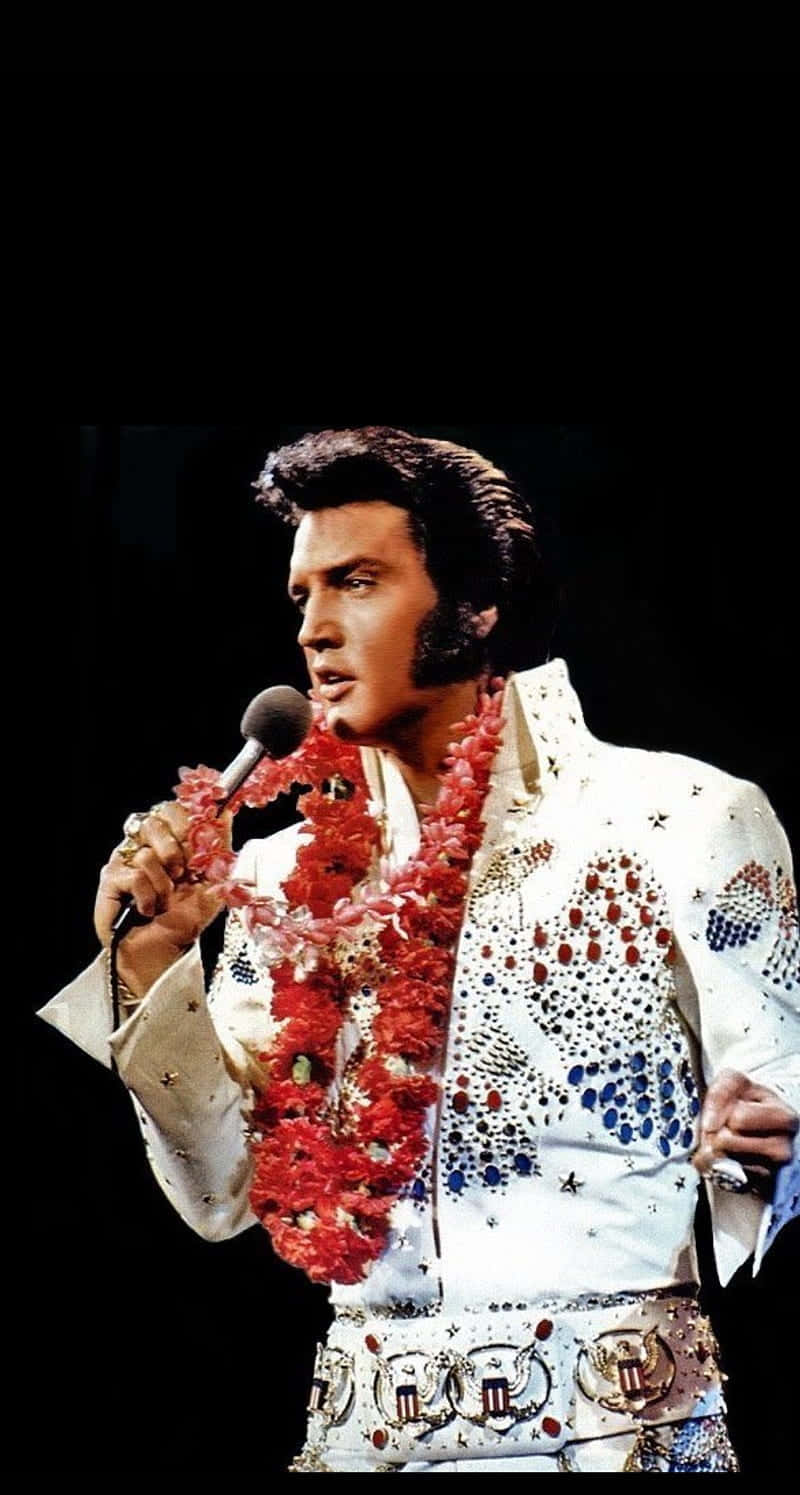 Elvis Presley In A White Dress Singing Into A Microphone Background