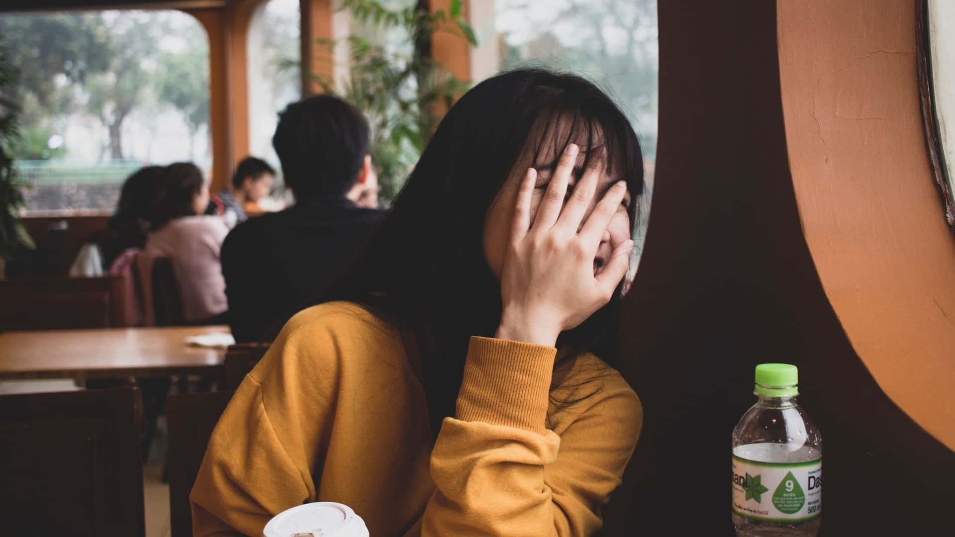 Embarrassed Woman Hiding Facein Cafe.jpg Background