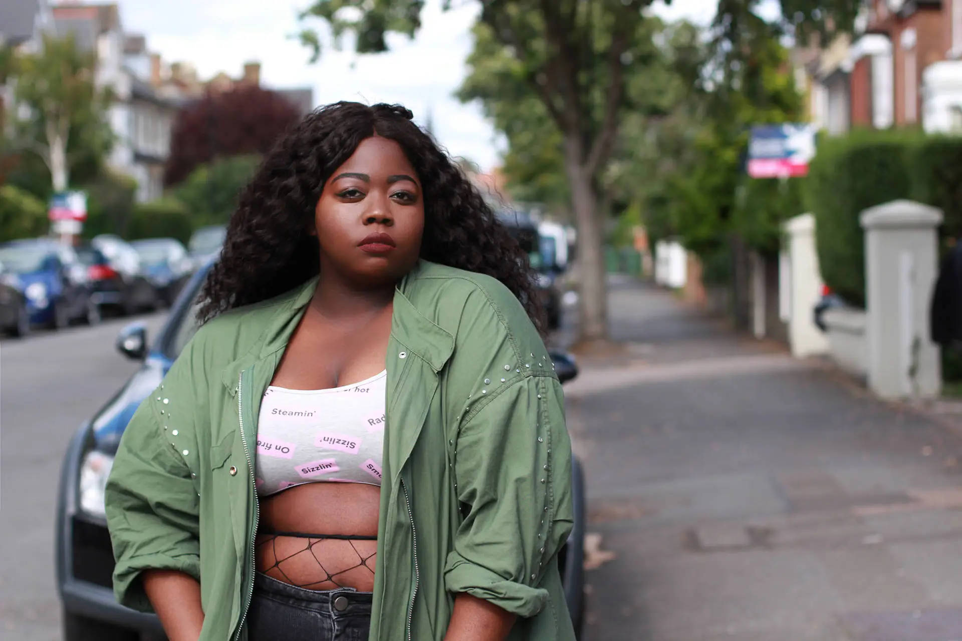 Embracing Individuality: A Confident Plus-sized African American Woman In Streetwear Background