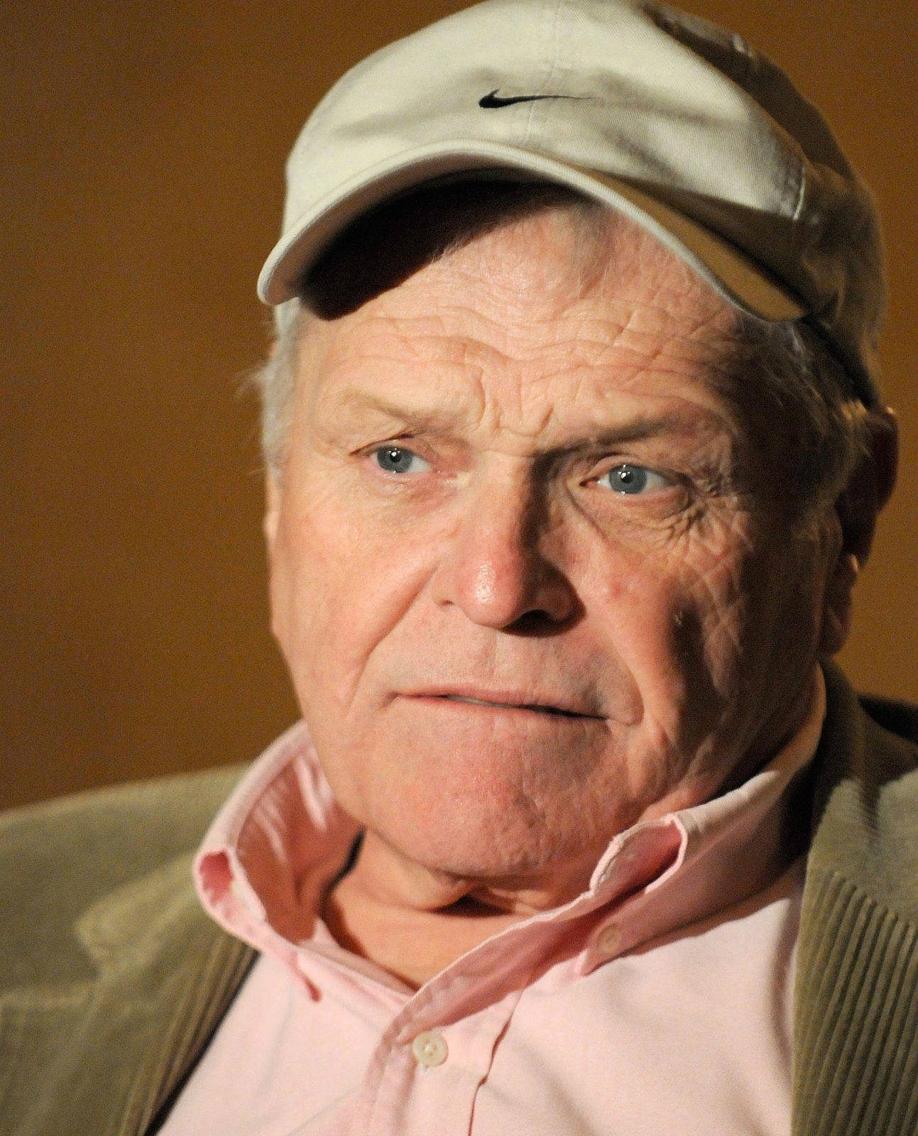 Eminent Actor Brian Dennehy Posing With A Brown Cap Background