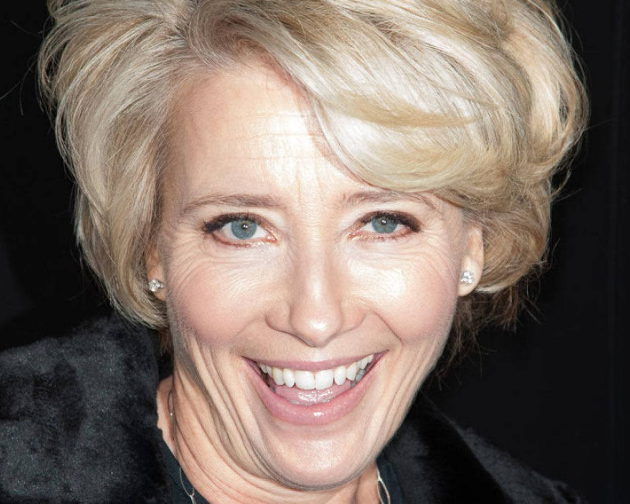 Emma Thompson Posing In An Elegant Fur Coat Background