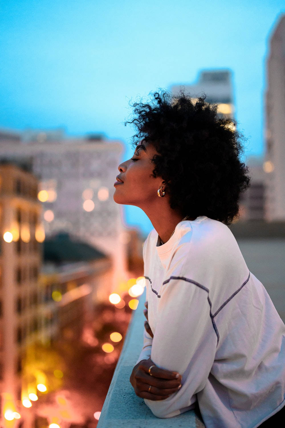 Empowered Black Woman Embracing The Night City Lights Background