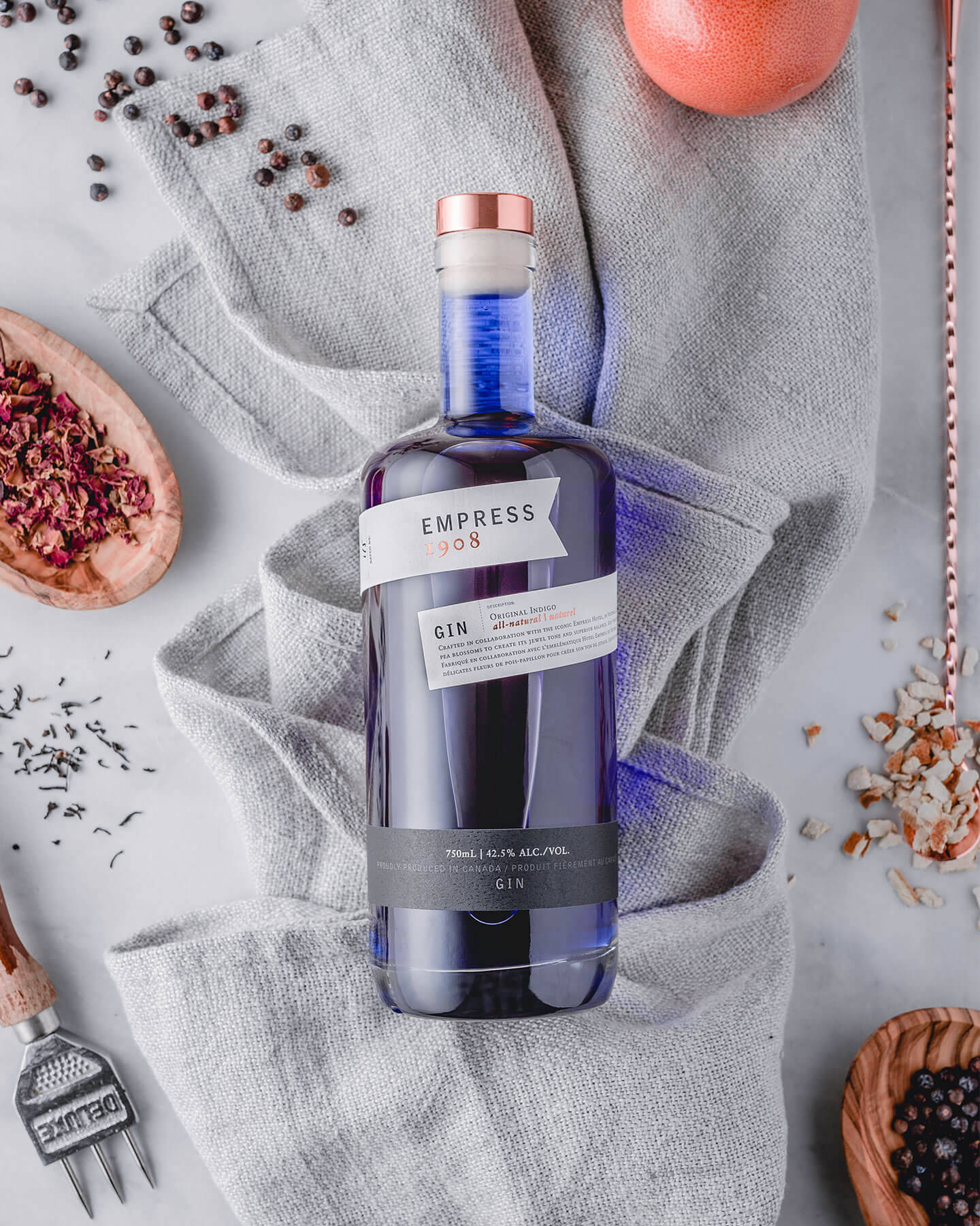 Empress 1908 Gin Flat Lay With Herbs Background