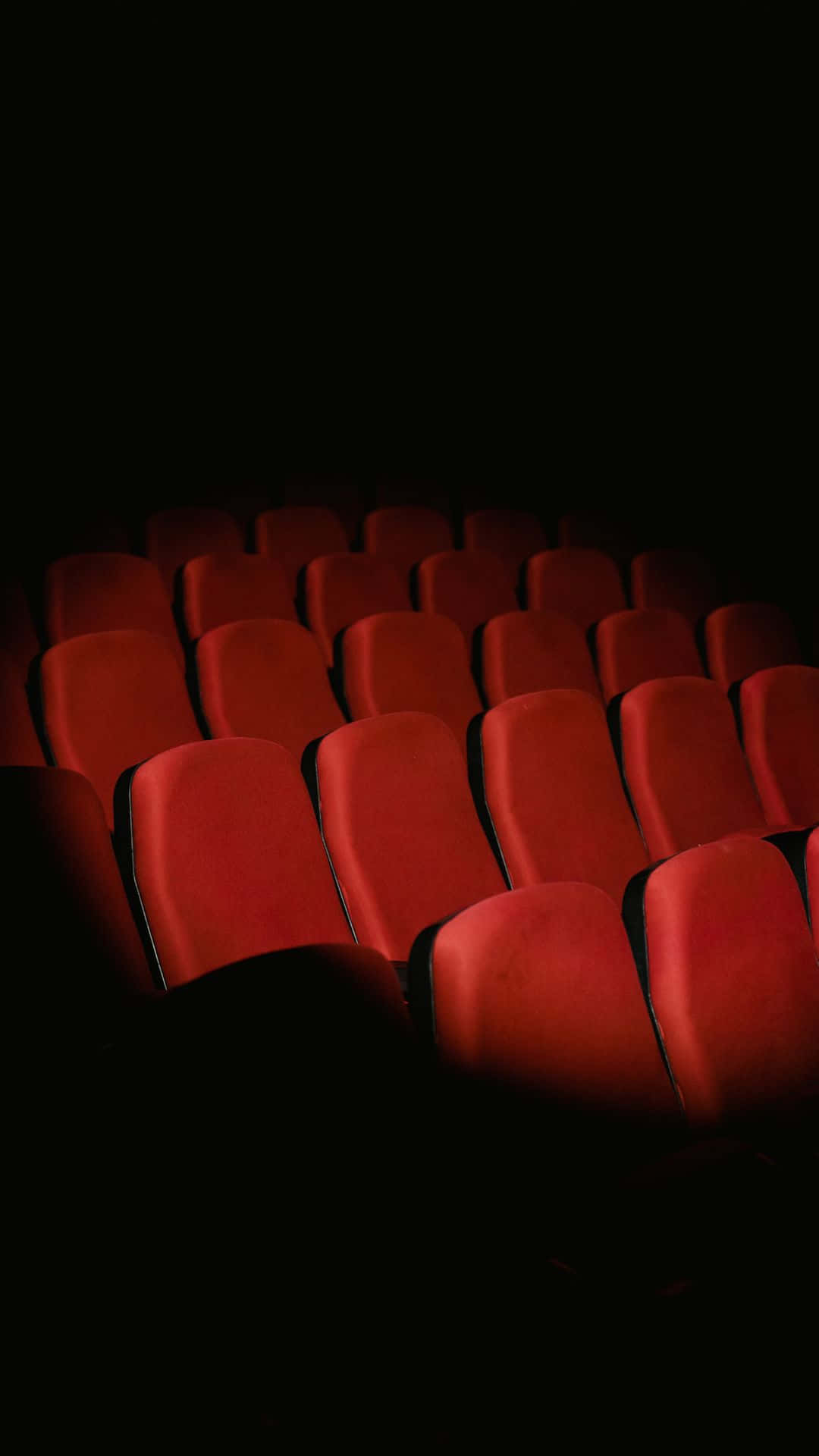 Empty Cinema Seatsin Darkness Background