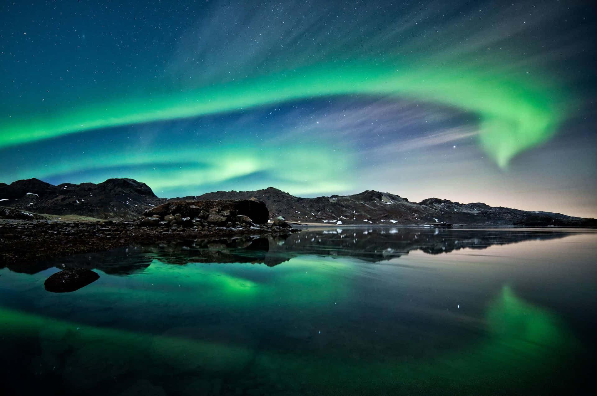 Enchanting Aurora Borealis Display Over A Tranquil Lake Background