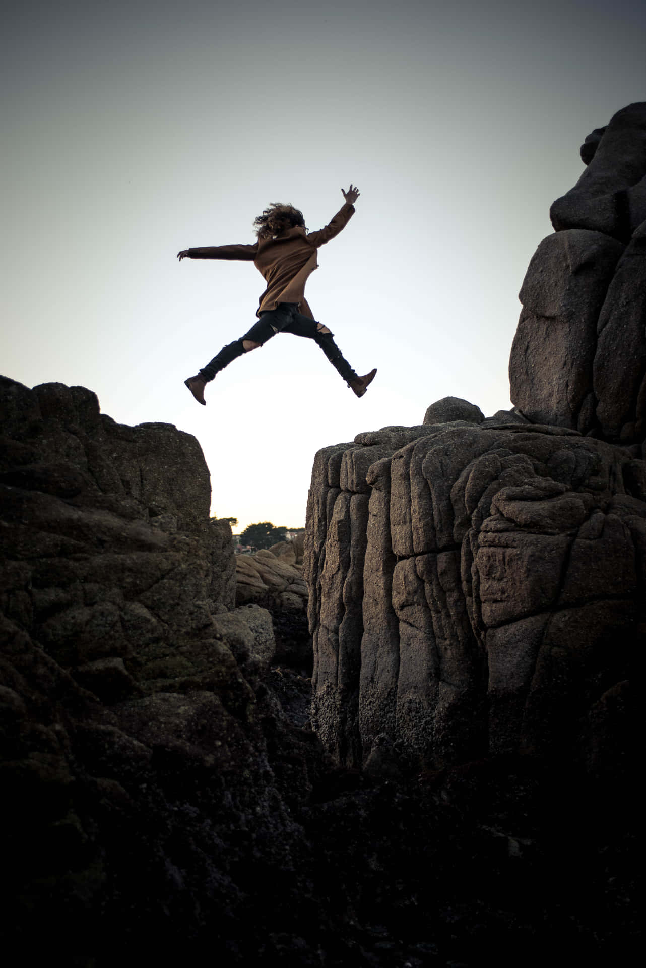 Energetic Leap On A Rocky Cliff