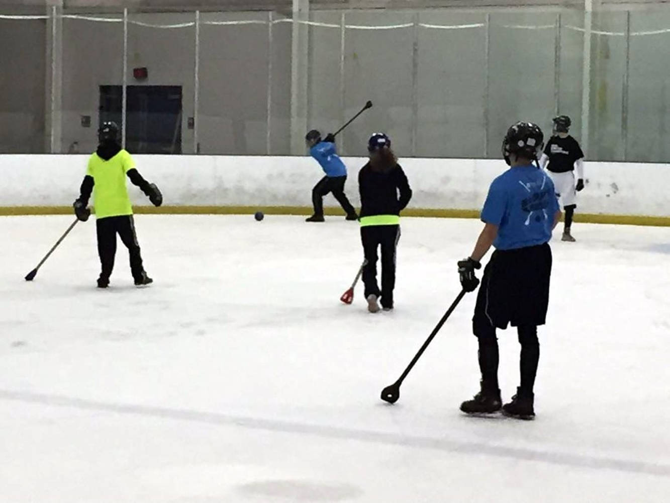 Energetic Young Players Engaged In A Broomball Game Background