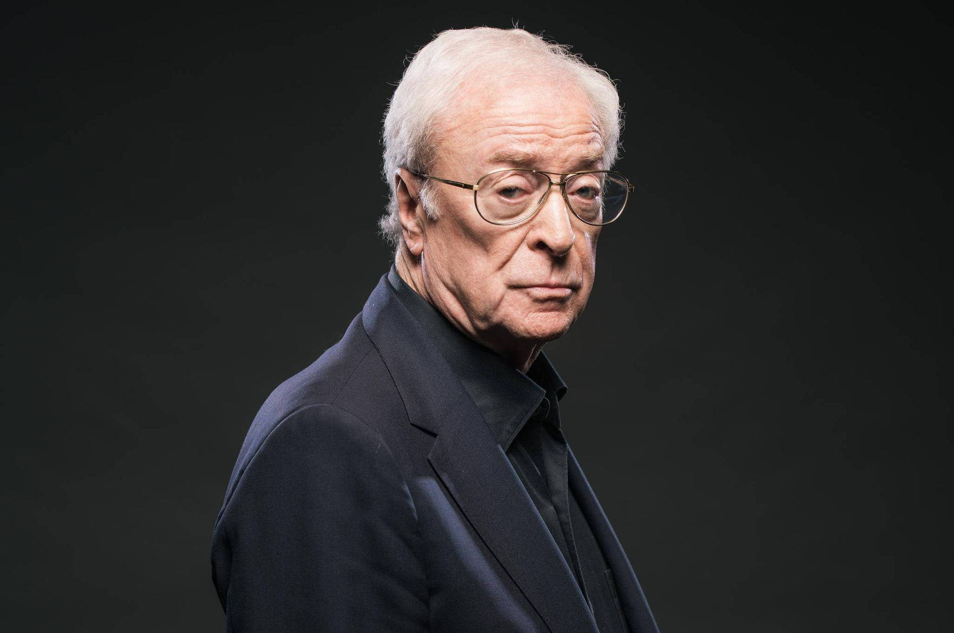 English Actor Michael Caine In Black Suit Background