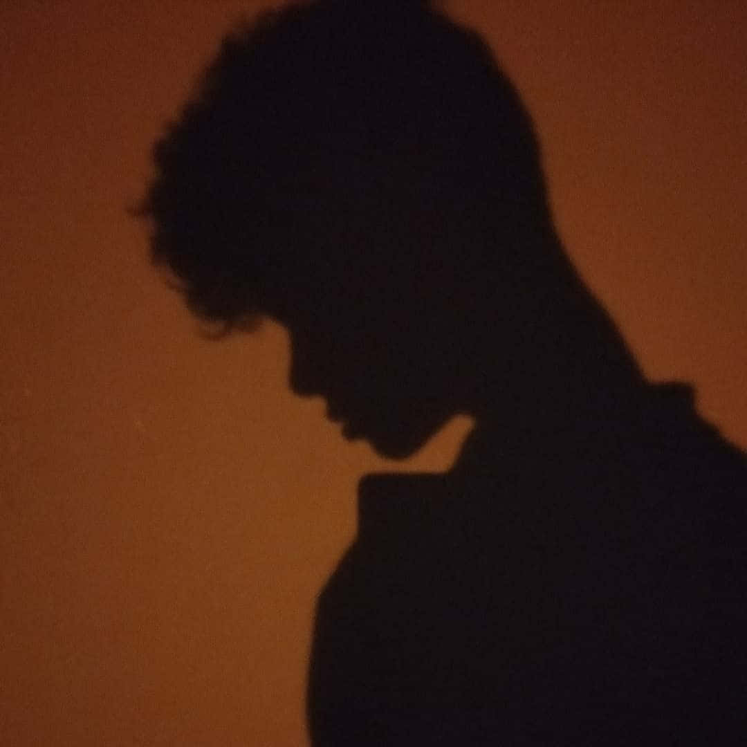 Enigmatic Curly-haired Figure In Shadow Pfp Background