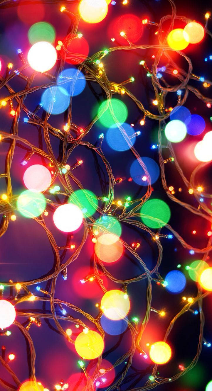 Enjoy A Festive Evening With Christmas Lights On Your Iphone Background