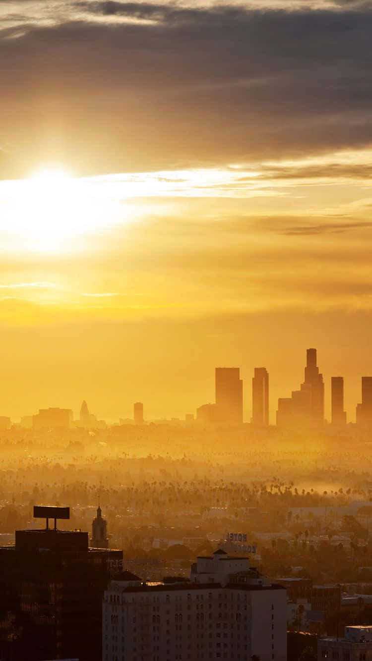 Enjoying A Scenic View Of Downtown Los Angeles While Using An Iphone Background
