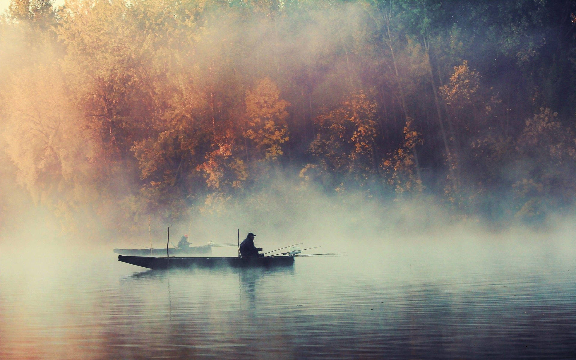 Enjoying An Early Morning Fishing Trip In A Misty Lake Background