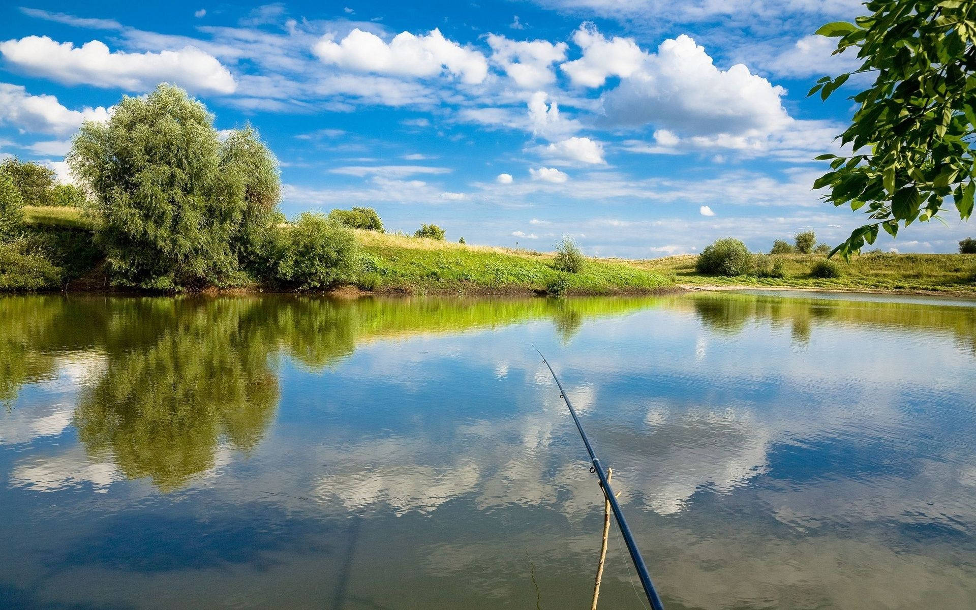 Enjoying Peace And Serenity At A Lake With A Fishing Rod Background