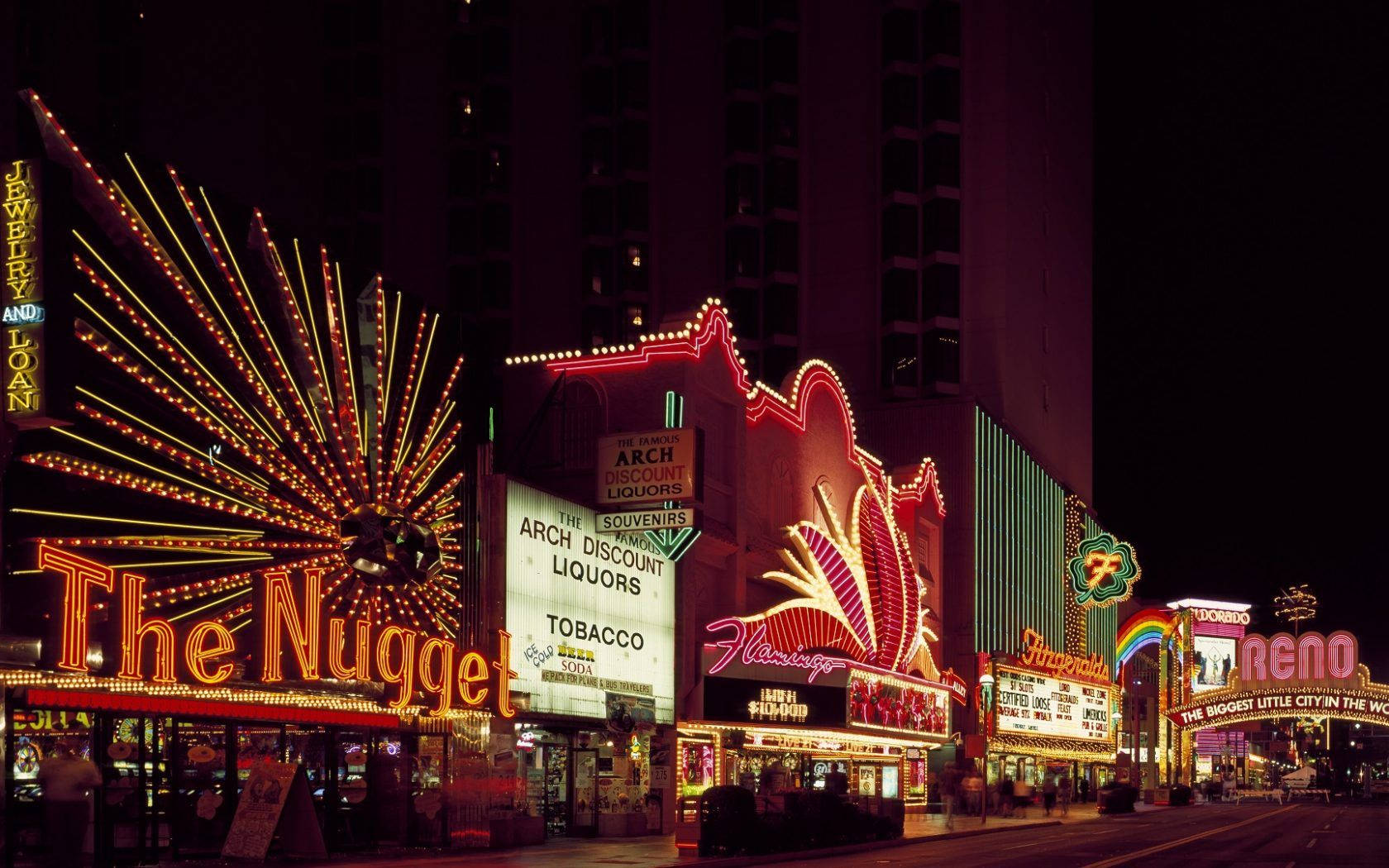 Enjoying The Vibrant Lights Of Reno's Strip At Night Background