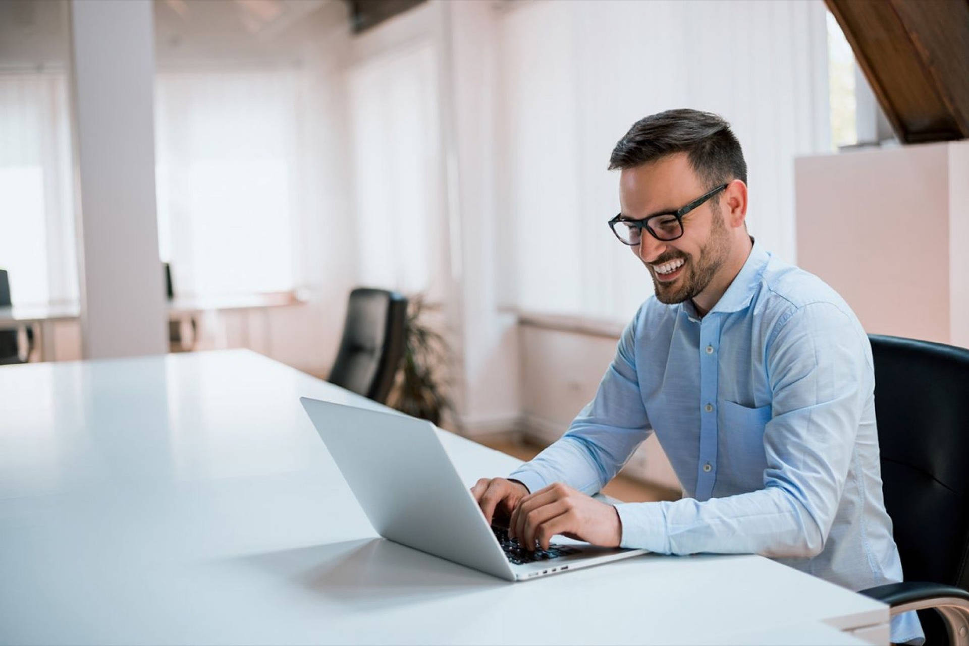 Entrepreneur Smiling While Working On Laptop Background