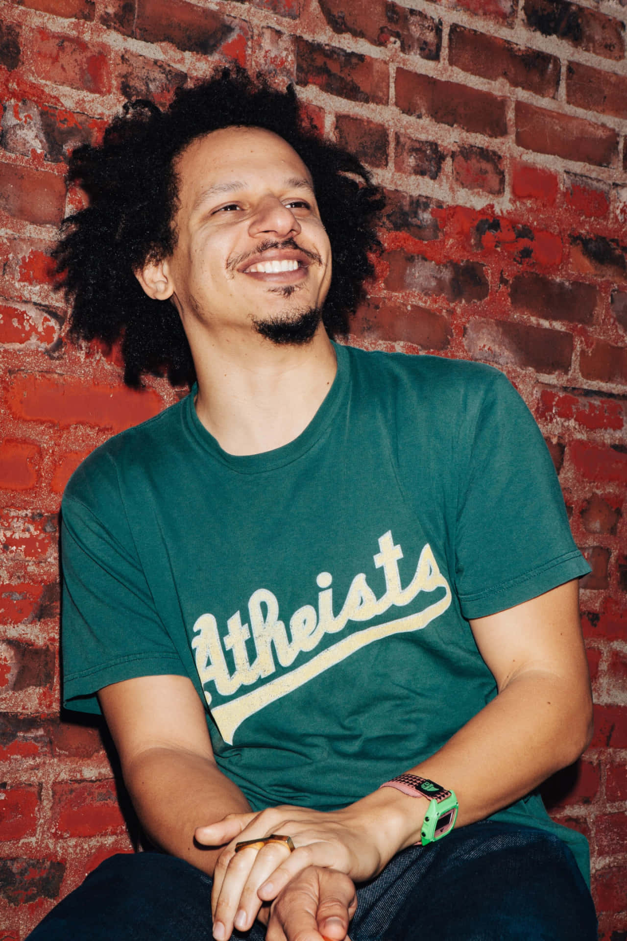 Eric Andre Smiling Brick Wall Background Background