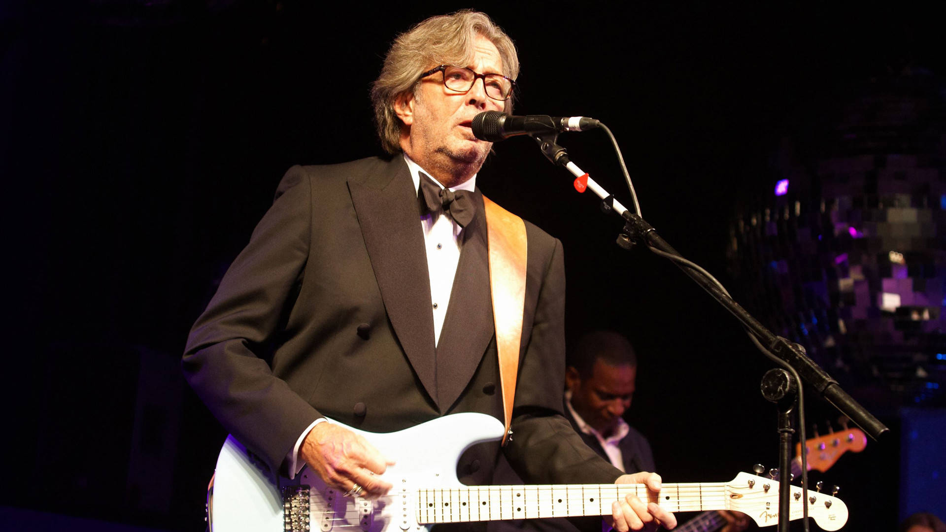 Eric Clapton Playing Guitar In Tuxedo Background