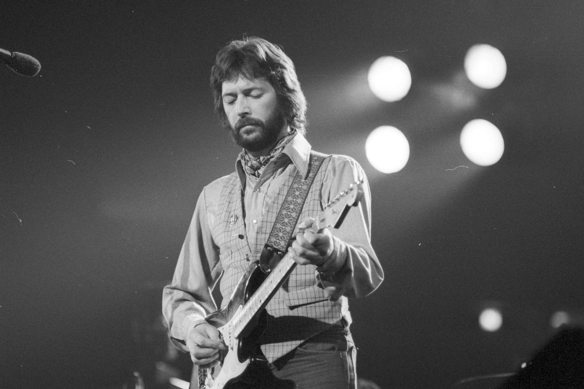 Eric Clapton Playing Guitar On Stage Background