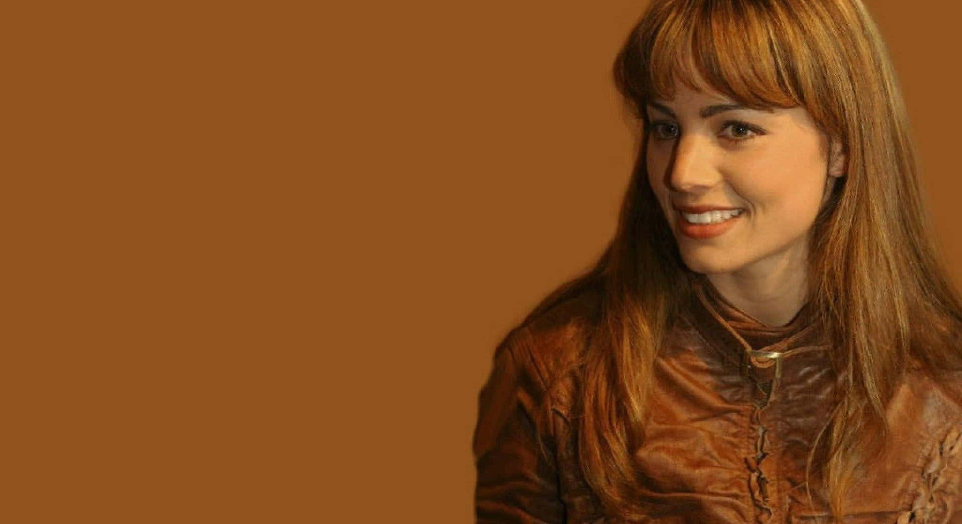 Erica Durance Smilingin Brown Leather Jacket Background