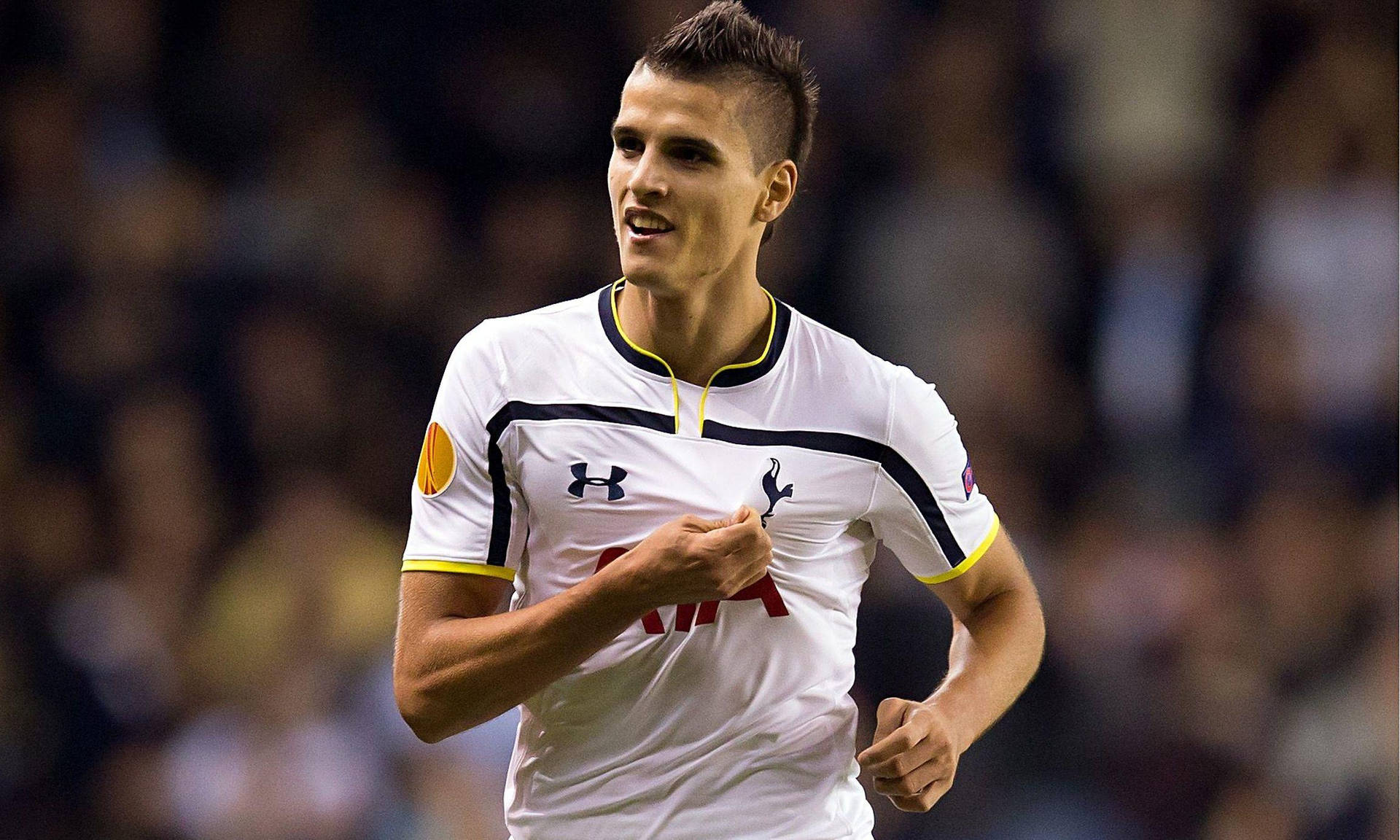 Erik Lamela Clutching Team Logo Background