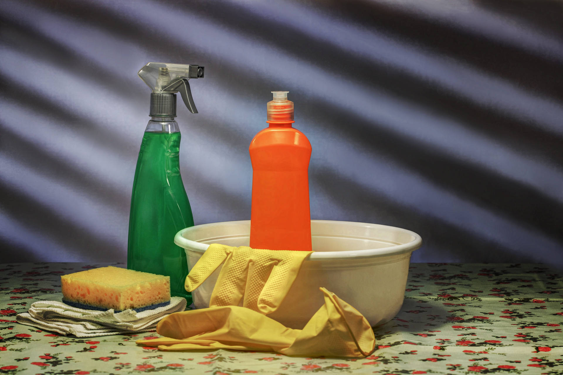 Essential House Cleaning Tools In A Basin Background