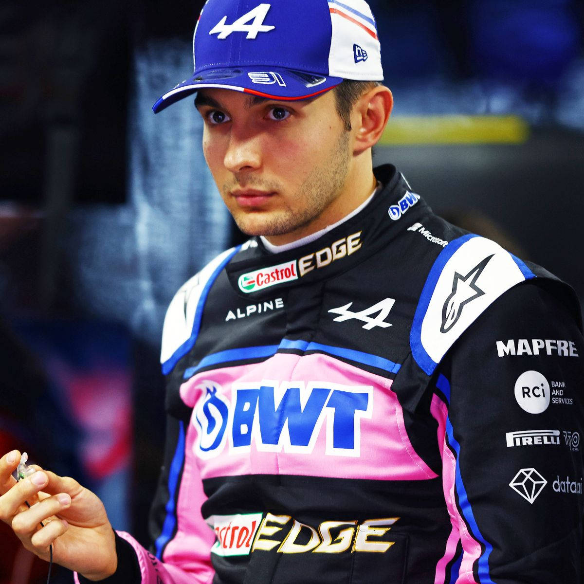 Esteban Ocon Sporting A Blue Cap Background