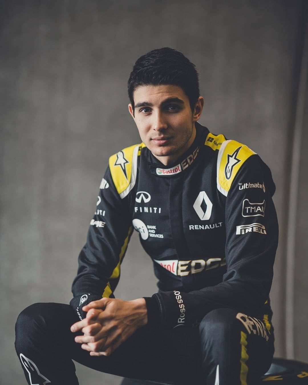 Esteban Ocon With Confident Pose Against Gray Backdrop Background