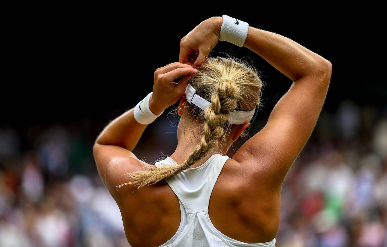 Eugenie Bouchard Adjusting Her Hair On The Court Background