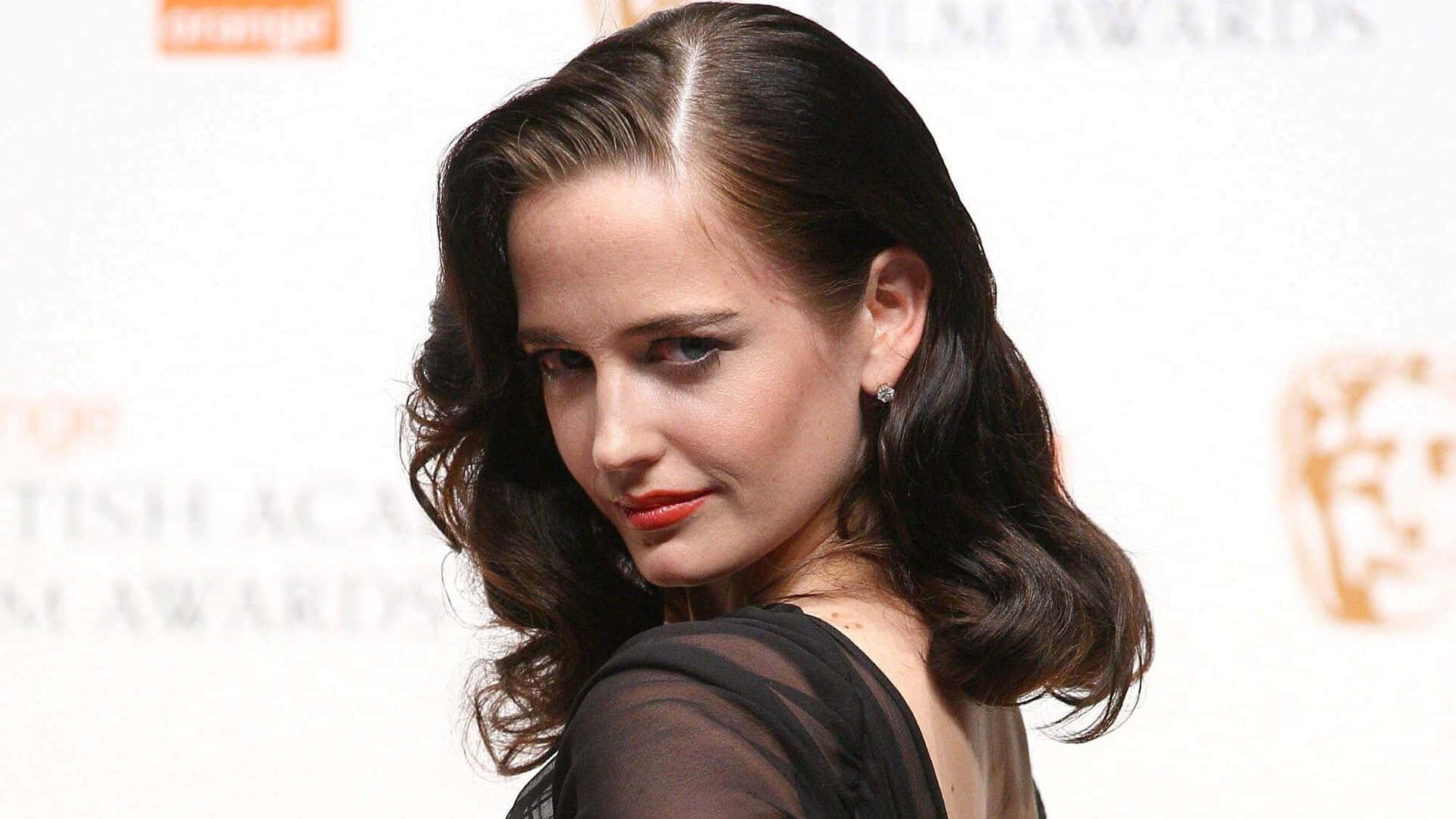 Eva Green Posing Elegantly In A Chic Outfit Background