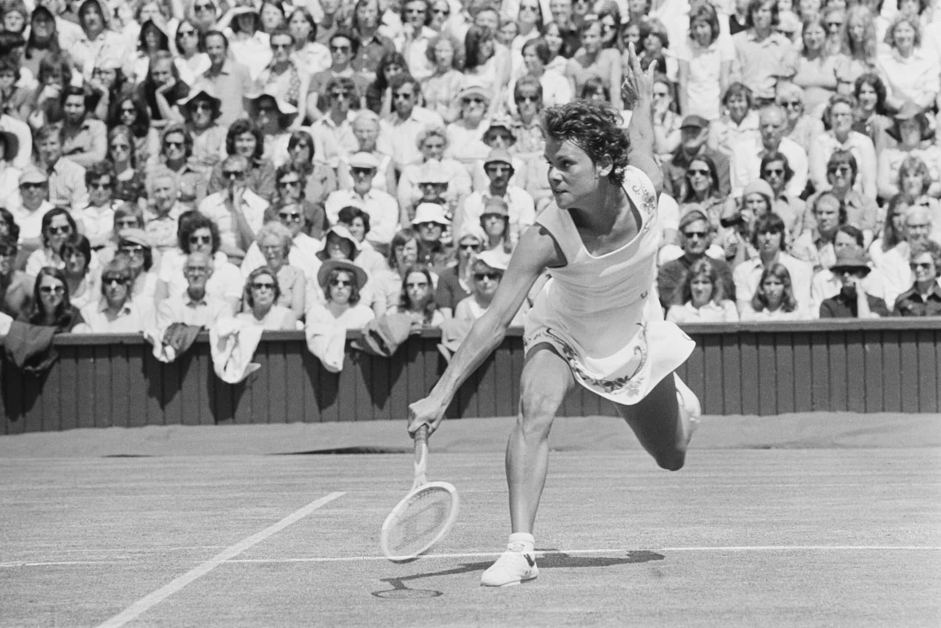 Evonne Goolagong Cawley, Dynamic Australian Tennis Player In Action—greyscale Snapshot Background