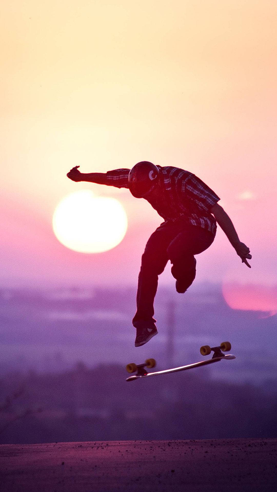 Exciting Mid-air Skateboard Stunt On Iphone Wallpaper Background