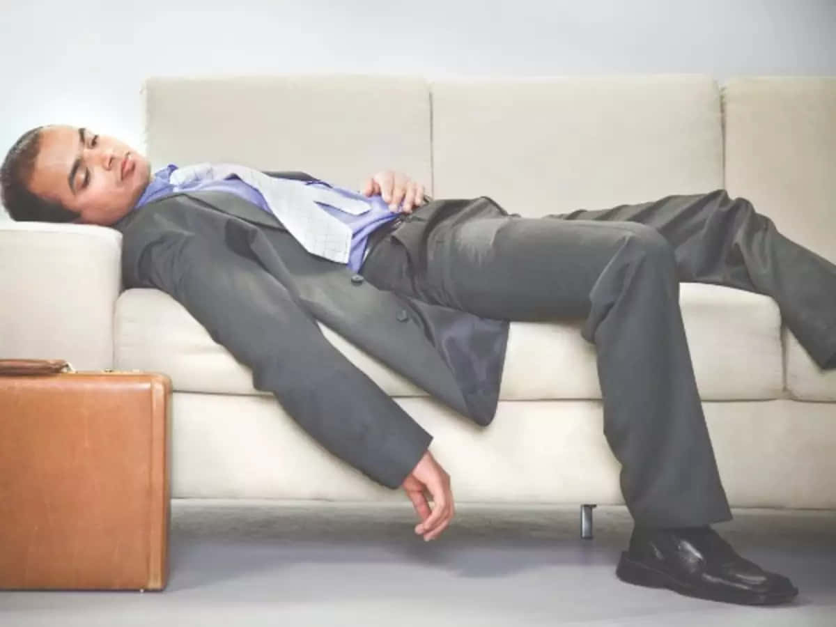 Exhausted Office Worker Taking A Break On Sofa Background