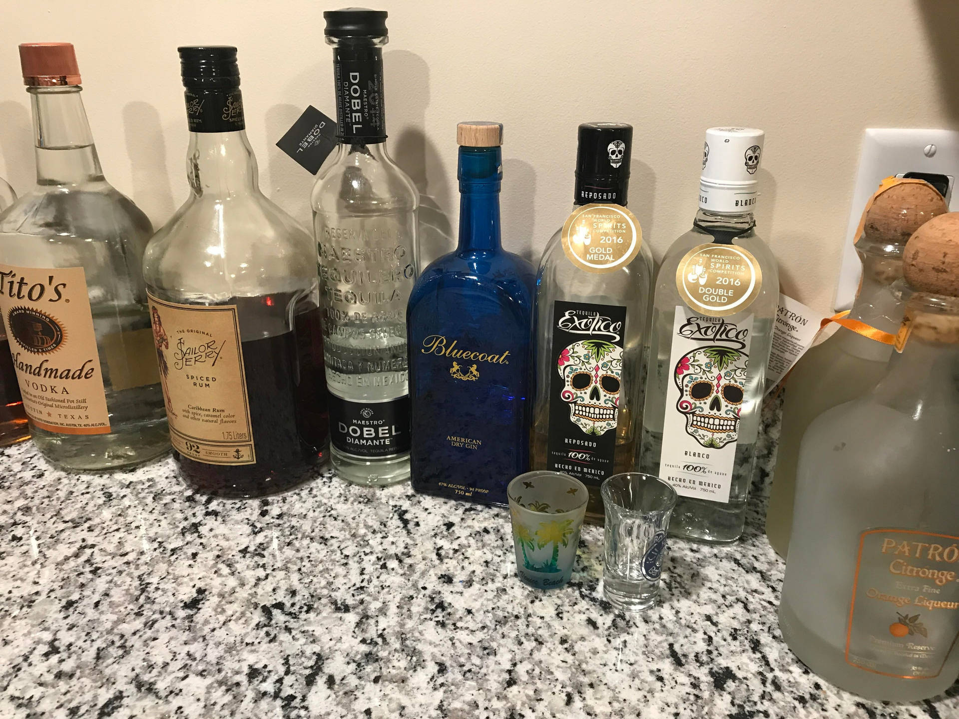 Exotico Tequila With Other Liquor Bottles Background