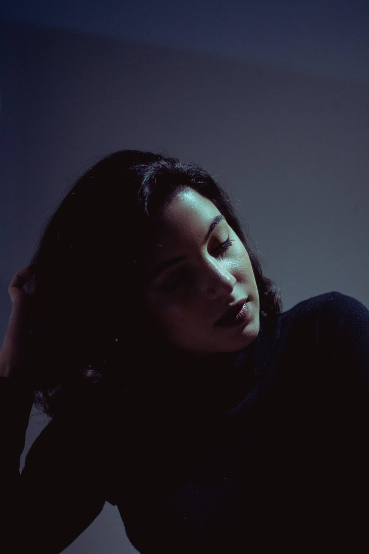 Expressive Latina Girl Embraced By Captivating Shadows Background