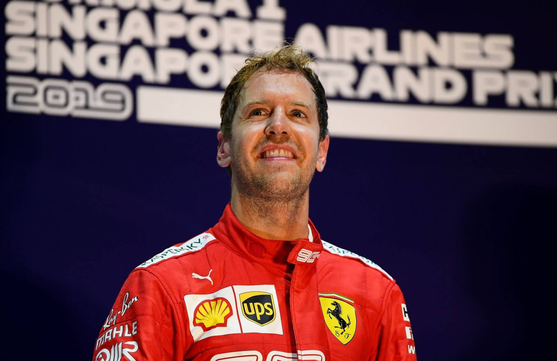 F1 Champion Sebastian Vettel Gazing Up Background