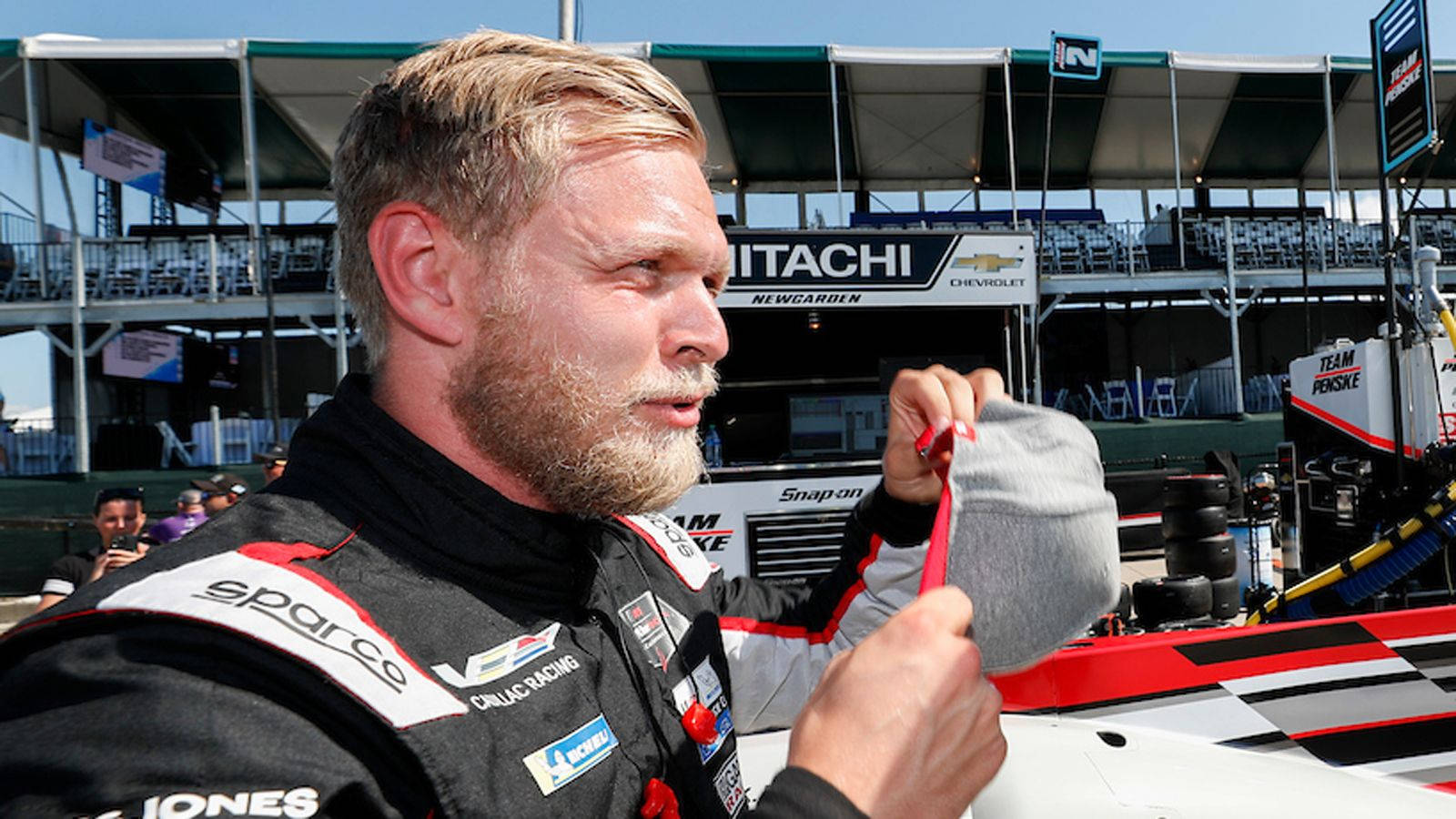 F1 Driver Kevin Magnussen Adjusting His Racing Cap Background