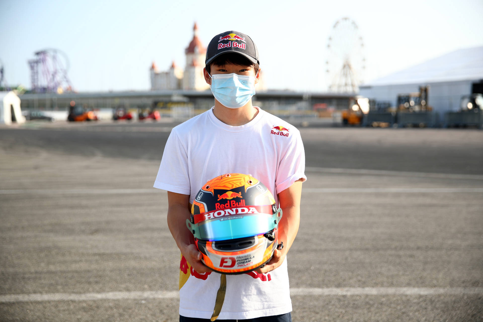 F1 Racer Yuki Tsunoda In Mask Holding Helmet
