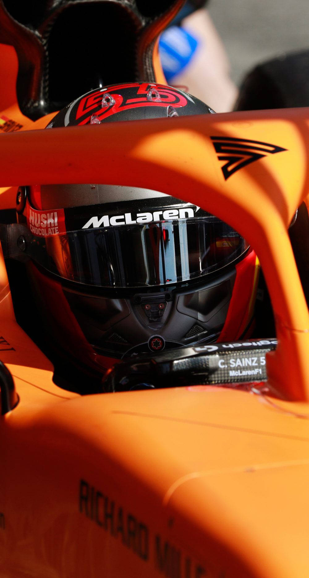 F1 Star Daniel Ricciardo Equipped With His Helmet In His Racing Vehicle Background