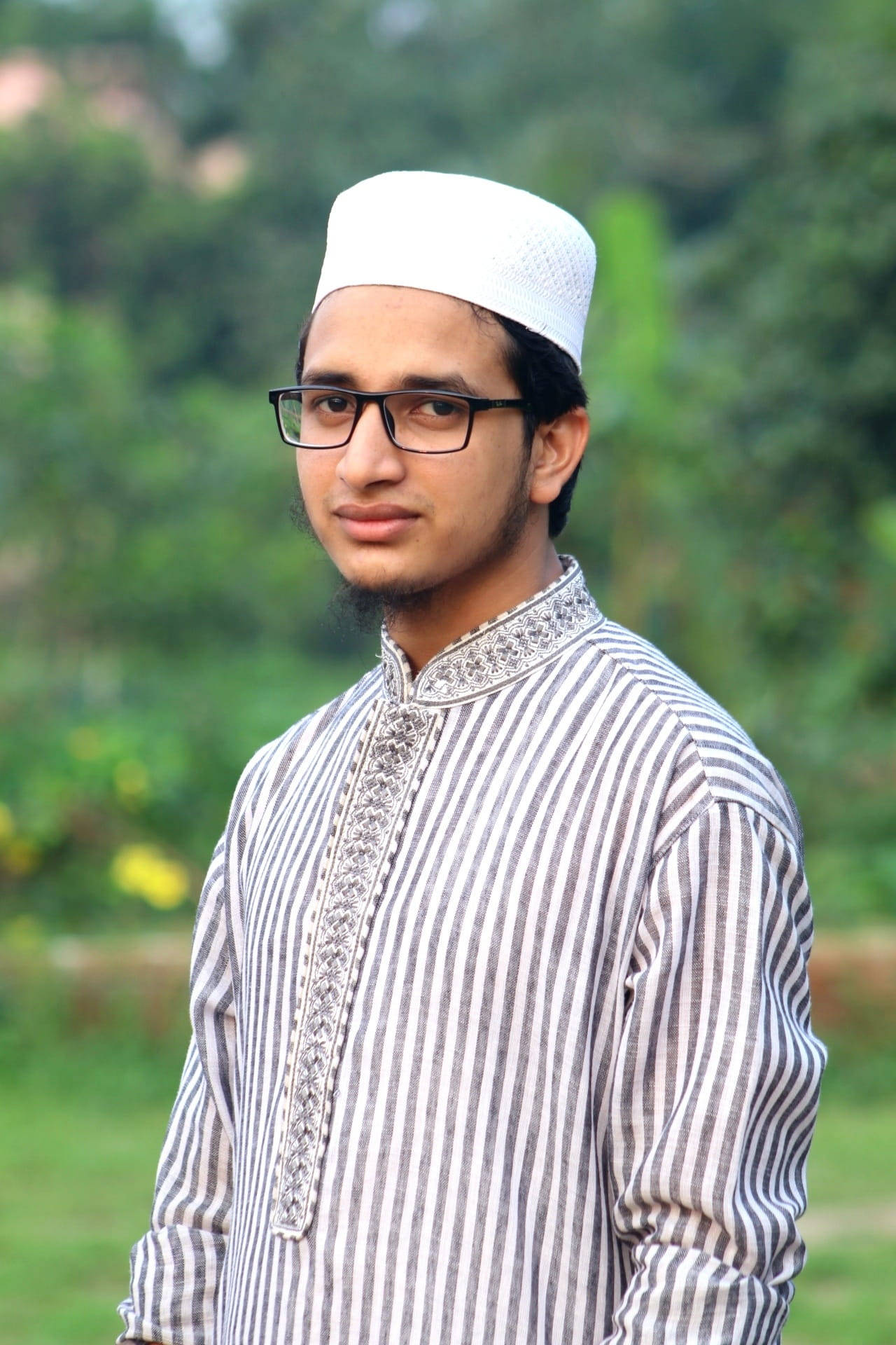 Faithful Young Islamic Boy In Traditional Attire Background