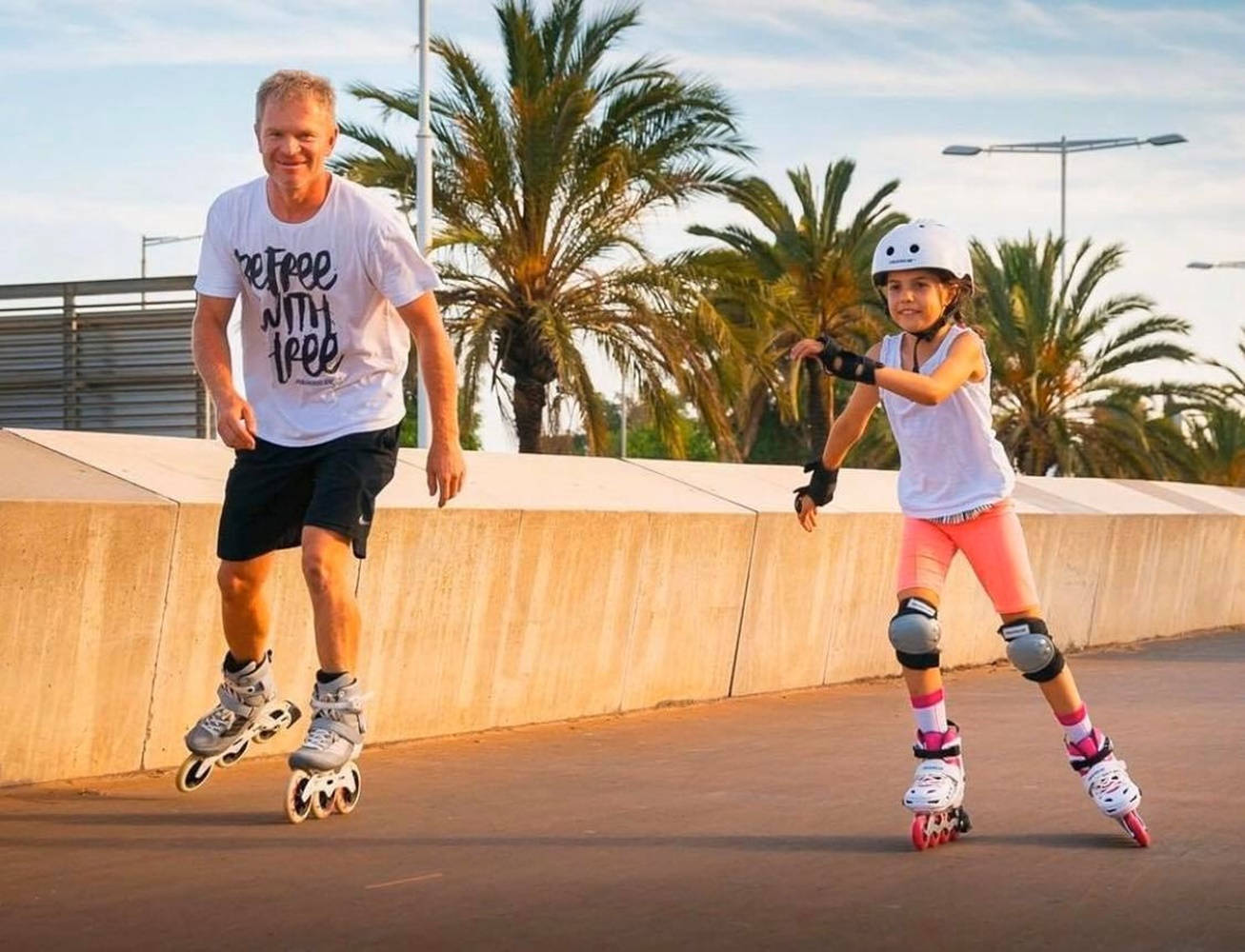 Father And Daughter Enjoying Rollerblading In Park