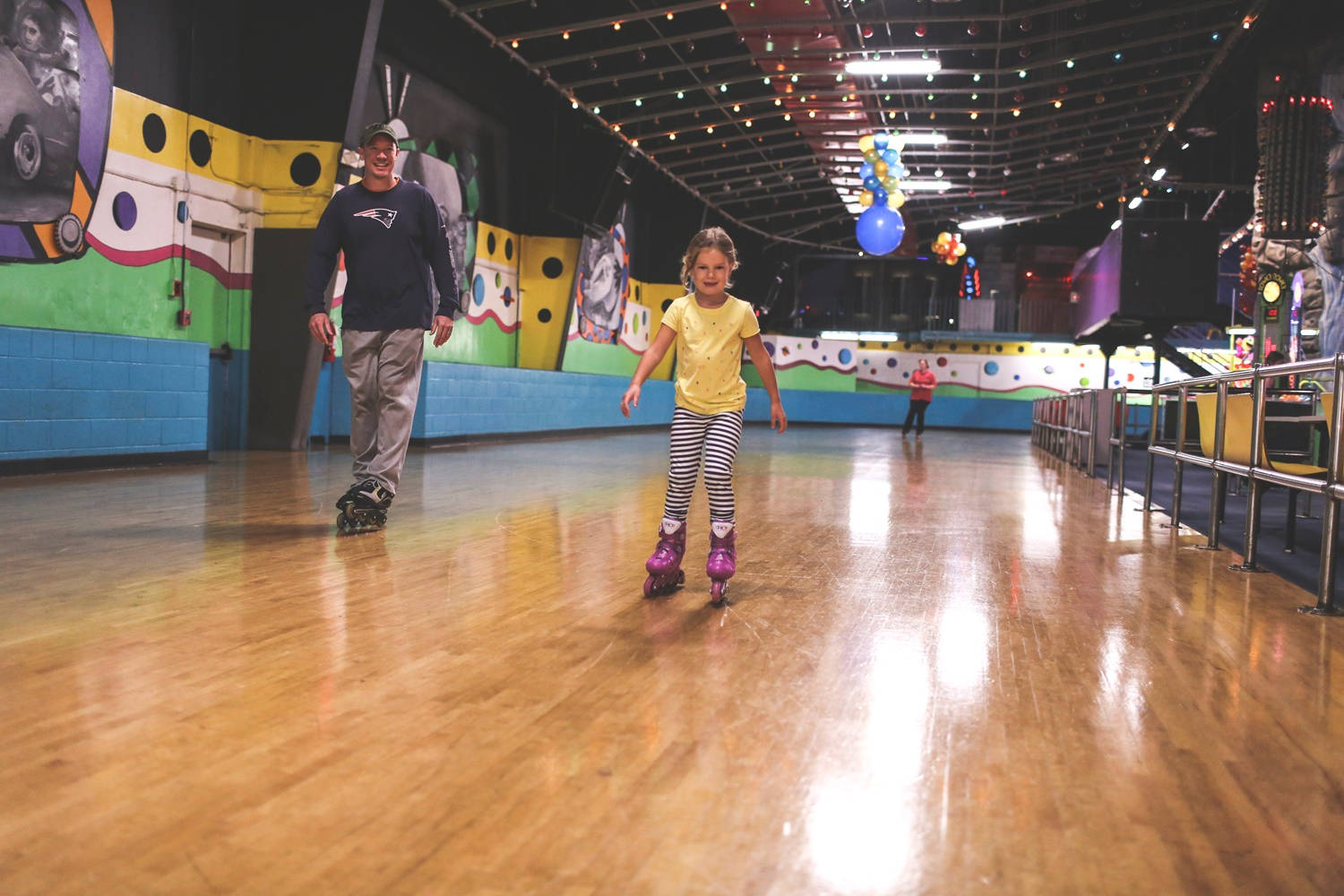 Father And Daughter Indoor Rollerblading Background