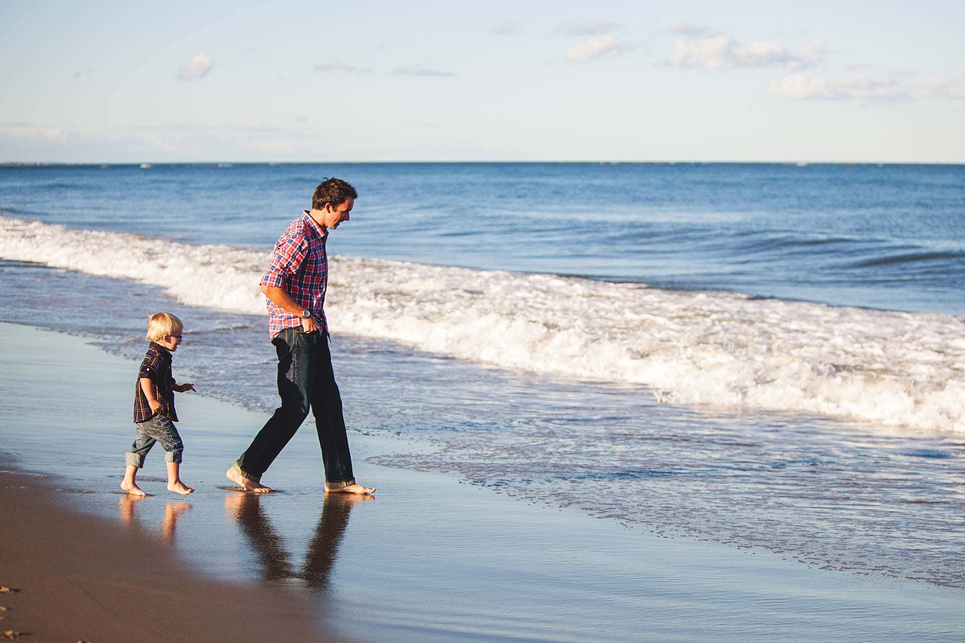 Father And Male Child Walking In Bare Feet Background