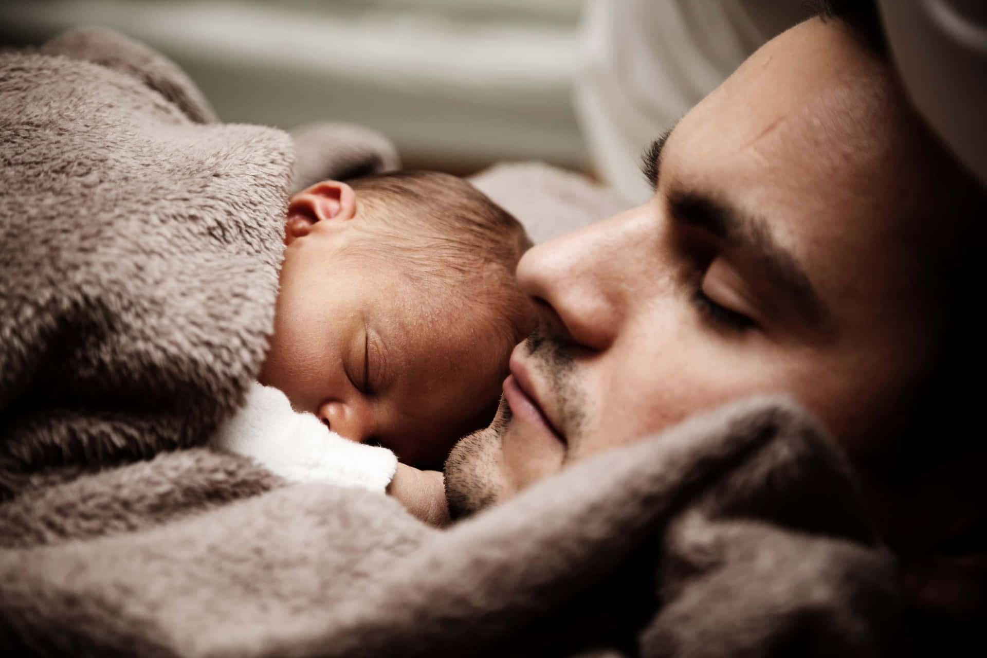 Father Sleeping With A Newborn Child