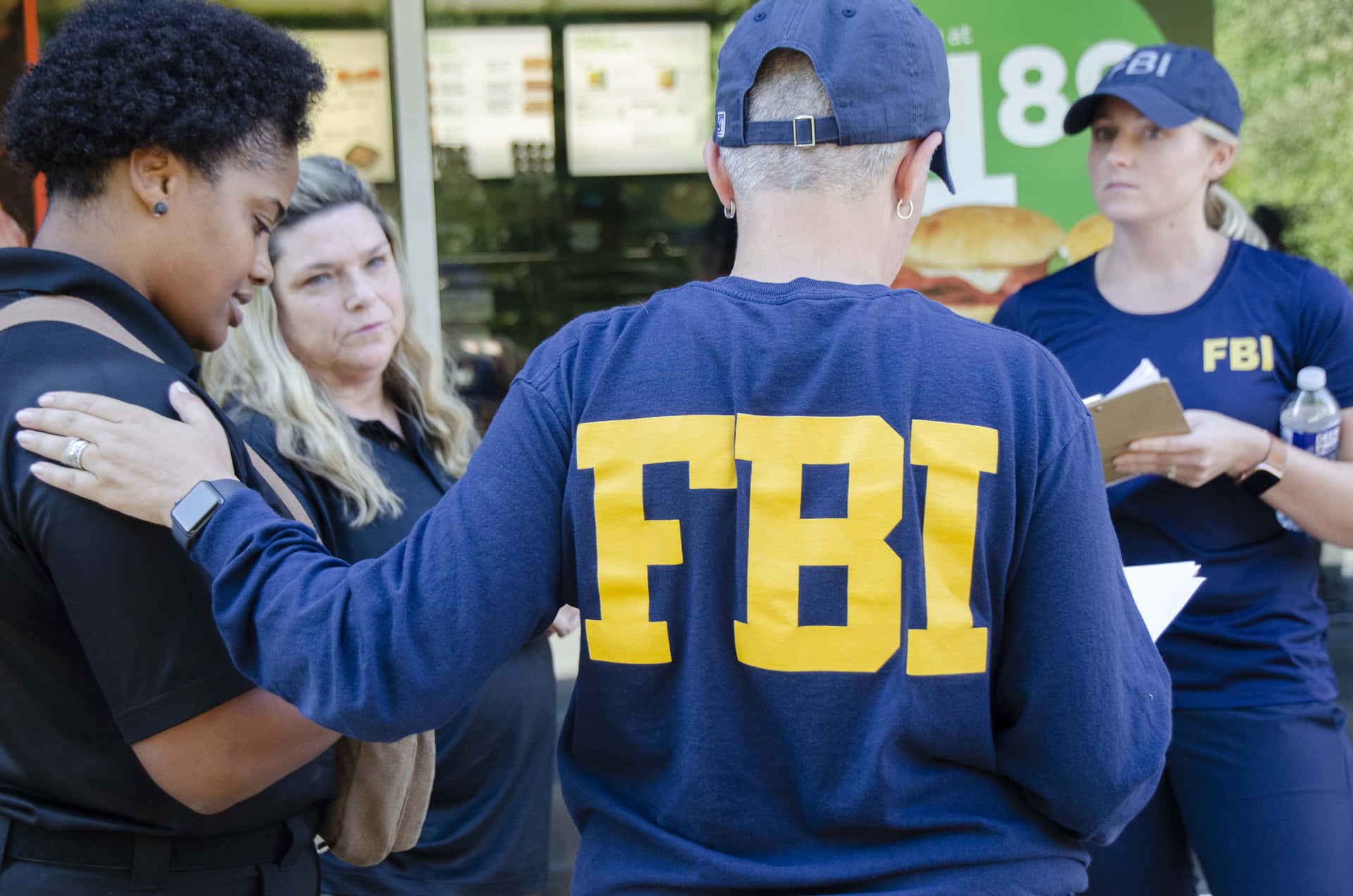 Fbi Agents In Uniform Standing Outside A Restaurant Background