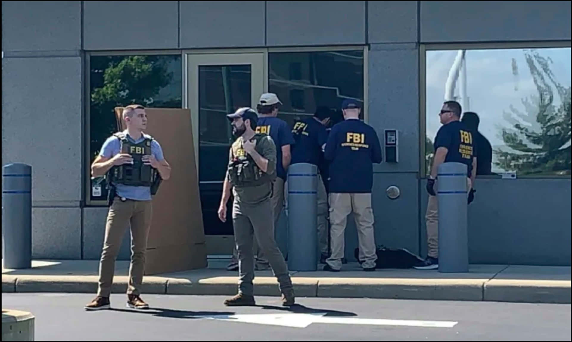 Fbi Agents Stand Outside A Building Background