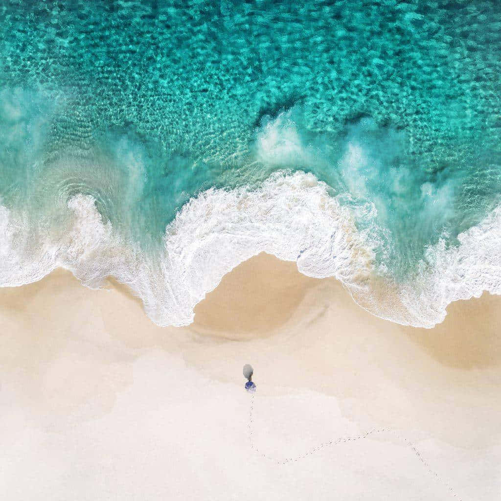 Feel The Sand Between Your Toes And The Cool Water On Your Skin With A Visit To Pretty Beach Background