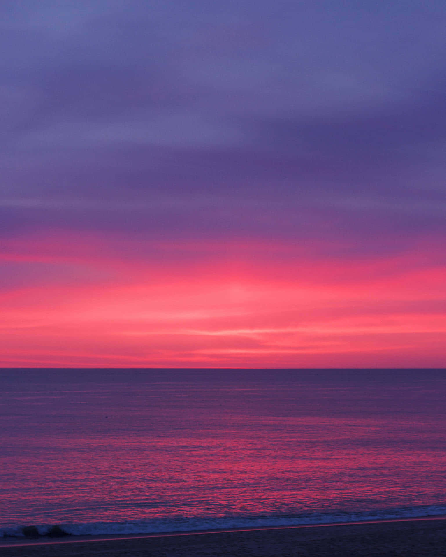 Feel The Warmth Of The Setting Sun On A Beautiful Pink Beach Background