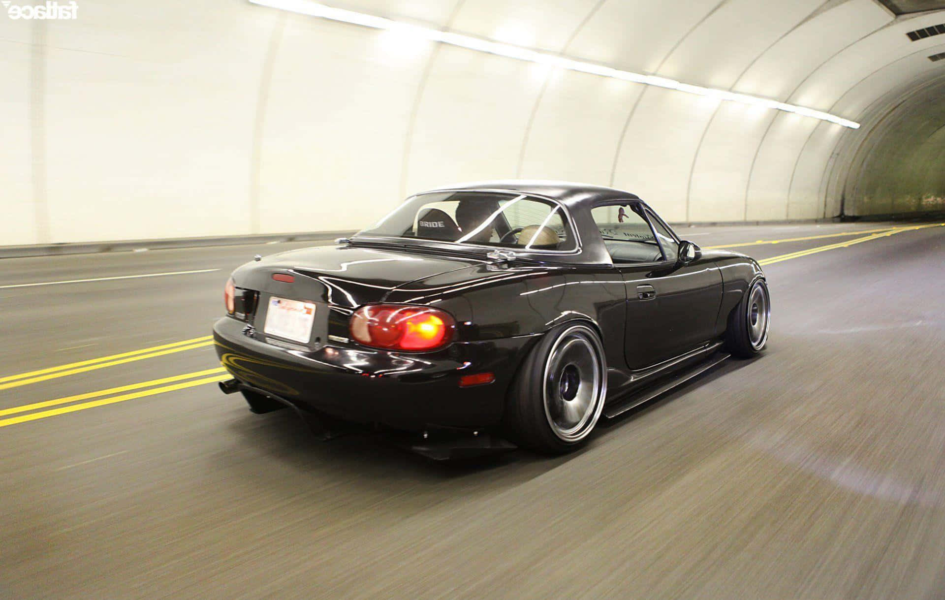 Feel The Wind While Driving In The Classic Mazda Miata Background