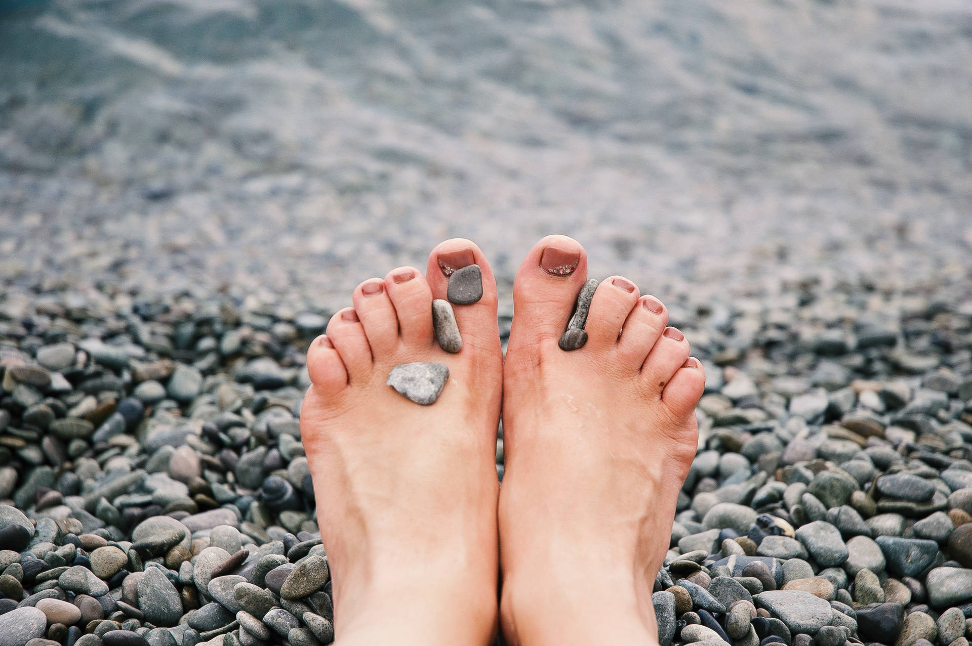 Feet On The Beach With Pebbles