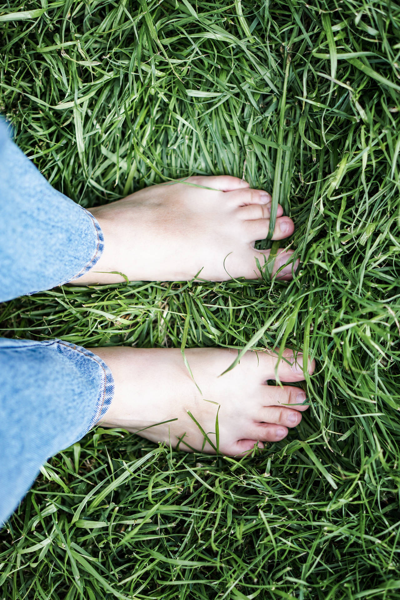 Feet Standing On Thick Grass Background